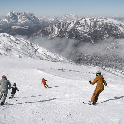 Familie beim Skifahren in den alpinen Bergen.
