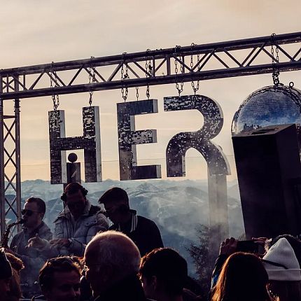 Crowd at an outdoor music festival on a mountain with a stage labeled 'HERO'.
