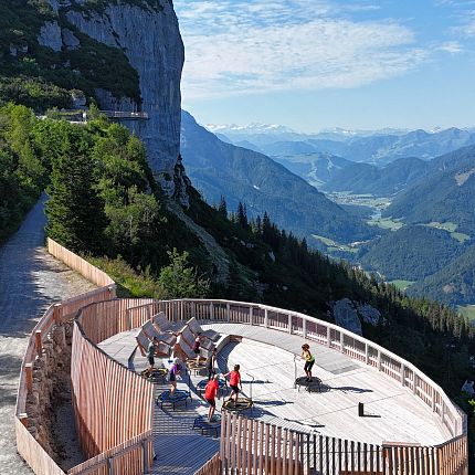 Cyclists on an observation deck overlooking mountains and valleys.