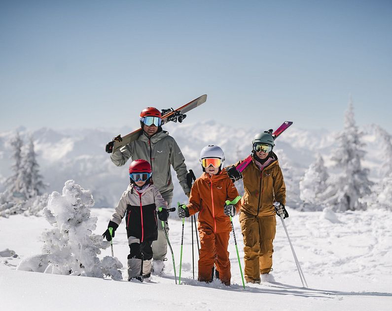 Familie in Skikleidung in schneebedeckter Berglandschaft