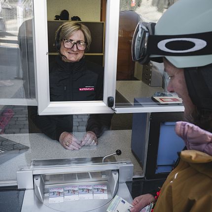 Skifahrerin an Kassa bezahlt an Kassa bei Ticketkauf